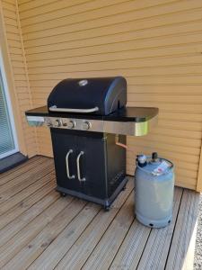 a grill sitting on a table on a deck with a trash can at own sauna, barbeque and backyard, free parking in Tampere