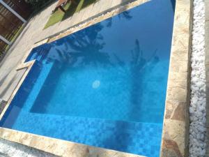 a blue swimming pool with rocks around it at Kaas Villas in Dickwella