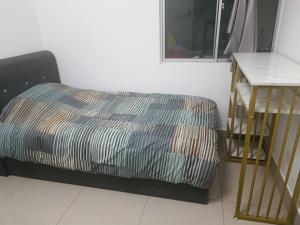 a bedroom with a bed and a nightstand next to a table at Razak City Centre KL SkyView 45th in Kuala Lumpur