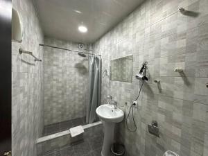 a bathroom with a shower and a toilet and a sink at Hotel Home in Tbilisi City
