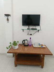 a wooden table with a tv on a wall at Homestay Sthanavi in Ujjain