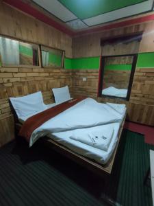 1 dormitorio con 1 cama en una habitación de madera en Hotel Mehak And Restarunt, en Pahalgām