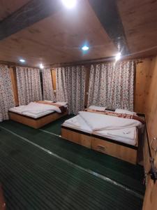 dos camas en un camarote en un barco en Hotel Mehak And Restarunt, en Pahalgām