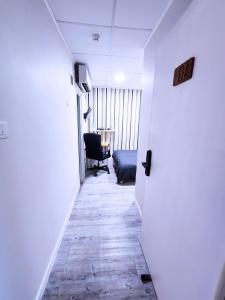 a hallway with a chair and a desk in a room at Pillows CoLiving in Hong Kong