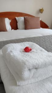 a white towel with a red candle on a bed at FRIENDS House - Central Station - Self Check-in in Braşov +29 photos