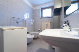 Un baño blanco con lavabo e inodoro. en Cesa Azola, en Vigo di Fassa 7 fotos más