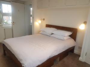 1 dormitorio con 1 cama con sábanas y almohadas blancas en One Home, en Oxford