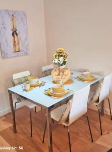 a dining room table with chairs and a vase of flowers on it at Spacious Duplex 2 Bed Apartment Central Location By Canal - Chester UK in Chester