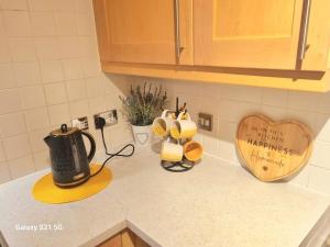 a kitchen counter with a tea kettle and a heart on the wall at Spacious Duplex 2 Bed Apartment Central Location By Canal - Chester UK in Chester +12 photos