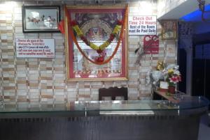 a wall with a picture and a sign on it at Goroomgo Mayagiri Patna in Patna