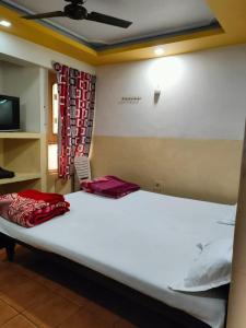 a bedroom with a large bed with a white bedspread at Goroomgo Mayagiri Patna in Patna