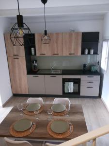 a kitchen with a wooden table with chairs and a kitchen with a counter at Little House Pove del Grappa in Pove del Grappa