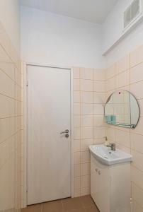 baño con puerta blanca y lavamanos en City Centre 3BD Apartment by Hostlovers, en Kaunas