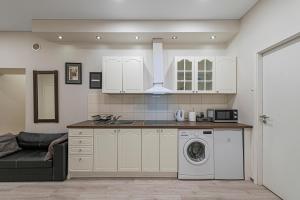 a kitchen with a washing machine and a couch at City Centre 3BD Apartment by Hostlovers in Kaunas