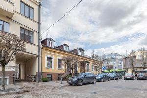 a row of cars parked on a street next to buildings at City Centre 3BD Apartment by Hostlovers in Kaunas