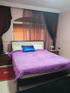 um quarto com uma cama roxa e uma almofada azul em Villa Mima em Marrakech