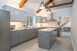 a kitchen with gray cabinets and a large island at Tranquil house with hot tub BBQ wheelchair access in Llandeilo