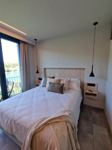 a bedroom with a large white bed and a window at Casa do Barqueiro LOUREIRA in Castrelo de Miño