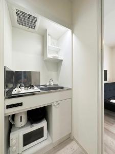 尾道市にあるbHOTEL Yutori - Homestyle 1BR Apartment in Onomichi for 3 Pplの白いキッチン(シンク、電子レンジ付)