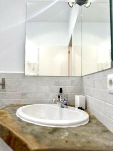 a white sink in a bathroom with a mirror at El Gallinero de Rita in Gaucín