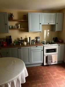 a kitchen with white cabinets and a stove top oven at Invercassley cottage in Lairg