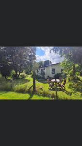 a picnic table in front of a white house at Invercassley cottage in Lairg +28 photos