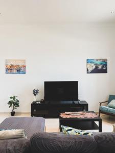 sala de estar con 2 sofás y TV de pantalla plana en Pembroke Parkside Maisonette, en Pembroke