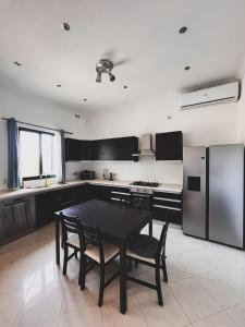 a kitchen with a black table and chairs in it at Pembroke Parkside Maisonette in Pembroke 