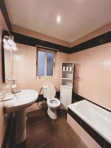 a bathroom with a sink and a toilet and a bath tub at Pembroke Parkside Maisonette in Pembroke 