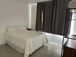 a bedroom with a white bed and a window at Casa na Reserva Sapiranga, Praia do Forte in Mata de Sao Joao +28 photos