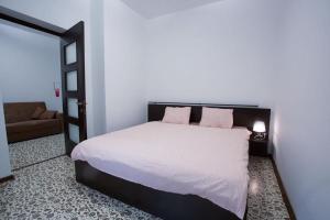 1 dormitorio con 1 cama con sábanas blancas y almohadas rosas en La Vila Maria, en Bucarest