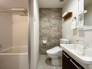 La salle de bains est pourvue de toilettes, d'un lavabo et d'une douche. dans l'établissement bHOTEL Yutori - 1Br Apartment in Onomichi City near the Station, à Onomichi