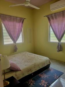 カンポン・ケママンにあるUmar's Tiny Houseのベッドルーム1室(紫色のカーテン付きのベッド1台、窓2つ付)