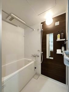 尾道的住宿－bHOTEL Yutori - Charming 1Br Apartment in Onomichi City for 3Ppl，带浴缸和盥洗盆的浴室