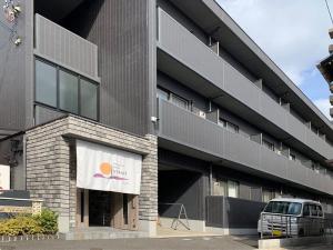 尾道的住宿－bHOTEL Yutori - Charming 1Br Apartment in Onomichi City for 3Ppl，停在前面的带货车的建筑