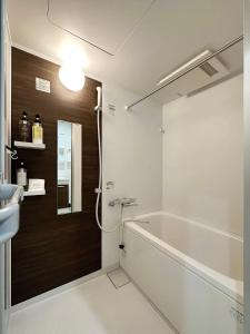 a bathroom with a bath tub and a sink at bHOTEL Yutori - Beautiful 1BR Apartment 6 mins walk to Station in Onomichi