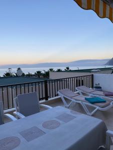 a table and chairs on a balcony with the ocean at Ocean View, Große Sonnenterrasse, Meerblick, Tamara Komplex, Teneriffa Süd, Los Gigantes, 500m Strand, Pool, 300m zum Ort, ruhig in Acantilado de los Gigantes
