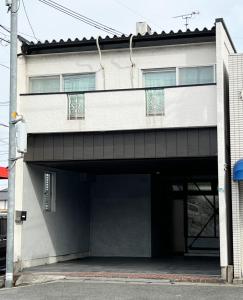 a building with a parking lot with a garage at 麗base野芥 in Fukuoka