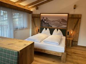 a bedroom with a large bed with white pillows at Nebenhaus Sagritzerwirt in Großkirchheim