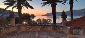 einen Sonnenuntergang über dem Wasser mit Palmen in der Unterkunft Accommodation Old Town Vitaic in Korčula