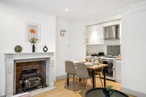 7a في لندن: مطبخ أبيض مع طاولة ومدفأة
