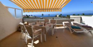 een tafel en stoelen op een balkon met uitzicht op de oceaan bij Ocean View, Große Sonnenterrasse, Meerblick, Tamara Komplex, Teneriffa Süd, Los Gigantes, 500m Strand, Pool, 300m zum Ort, ruhig in Acantilado de los Gigantes