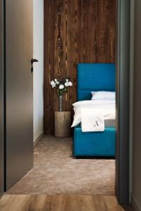スピンドレルフ・ムリンにあるAvenue Chaletのベッドルーム(青いベッド1台、花瓶付)