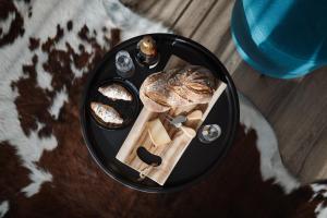a black plate with bread and cheese on a table at Avenue Chalet in Špindlerův Mlýn