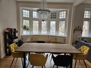 a dining room table with chairs and a chandelier at Residence am Rathausplatz 3 in Saarbrücken