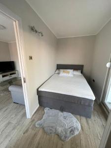a small bedroom with a bed and a television at Viewpoint in Belgrade
