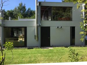 ein Haus mit einer schwarzen Tür und einem Hof in der Unterkunft vakantiehuis Veerse Meer met grote privétuin in Kamperland