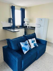 a blue couch with two pillows on it in a kitchen at Atena Flats in Aracaju