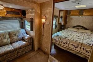 1 dormitorio en una cabaña con cama y sofá en The Dutchman (Presque Isle Campground #3) en Presque Isle