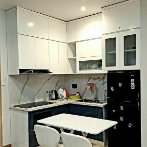 a kitchen with white cabinets and a table and chairs at Ha Long Bay View Studio in Ha Long